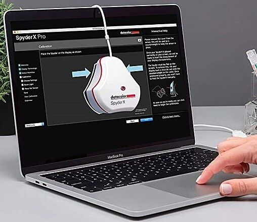 Laptop visar kalibrering med en SpyderX-färgsensor på skärmen